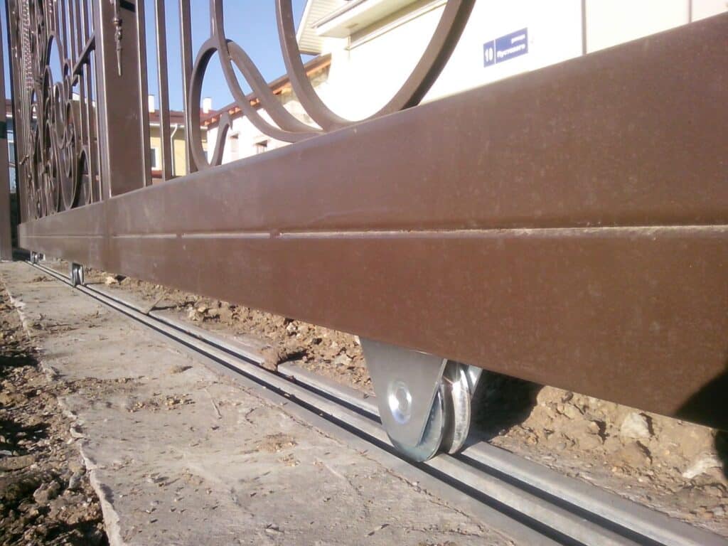 Betonozott alapba rögzített, horganyzott acél tolókapu sín szintezett és teherbíró kivitelben a TEMA szakemberei által.